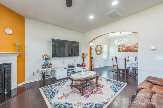 1012 Leland Dr, Wesley Chapel, NC 28104 - living area featuring arched walkways, recessed lighting, a chandelier, dark wood-style floors, and a glass covered fireplace