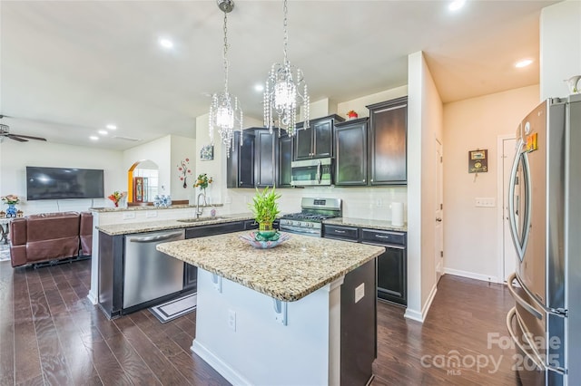 1012 Leland Dr, Wesley Chapel, NC 28104 - kitchen with stainless steel appliances, arched walkways, a peninsula, dark wood-style flooring, and recessed lighting