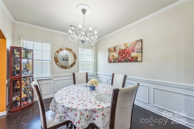 1012 Leland Dr, Wesley Chapel, NC 28104 - dining room with a chandelier, crown molding, dark wood-type flooring, a decorative wall, and a wainscoted wall