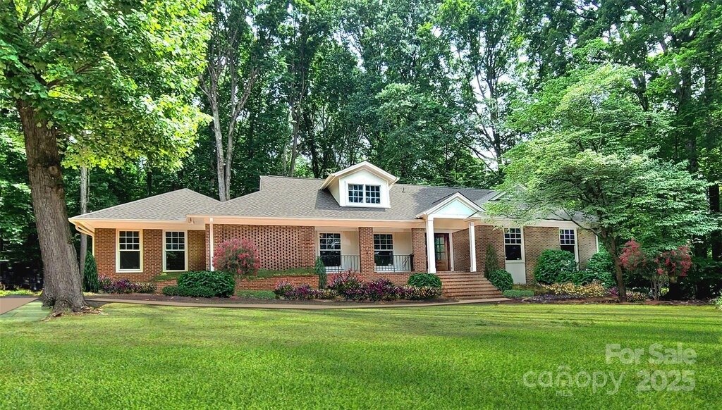 25 Fairway Rdg, Lake Wylie, SC 29710 - view of front of home with a front yard, brick siding, roof with shingles, and a porch