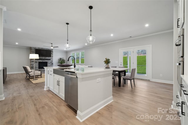 416 Balboa St, Matthews, NC 28104 - kitchen with stainless steel dishwasher, ornamental molding, ceiling fan, open floor plan, and a stone fireplace