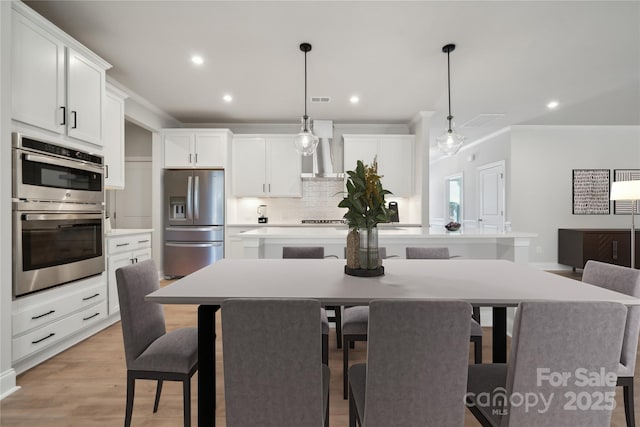 416 Balboa St, Matthews, NC 28104 - kitchen with stainless steel appliances, ornamental molding, decorative backsplash, wall chimney exhaust hood, and a kitchen island