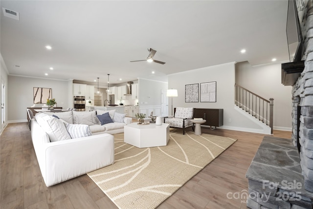 416 Balboa St, Matthews, NC 28104 - living room featuring a ceiling fan, stairway, recessed lighting, light wood-style flooring, and crown molding