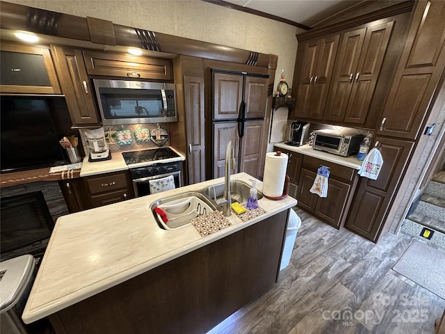 104 Cardinal Dr, New London, NC 28127 - kitchen with stainless steel microwave, oven, wood finished floors, light countertops, and crown molding