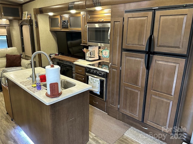 104 Cardinal Dr, New London, NC 28127 - kitchen with stainless steel microwave, oven, light wood finished floors, light countertops, and fridge