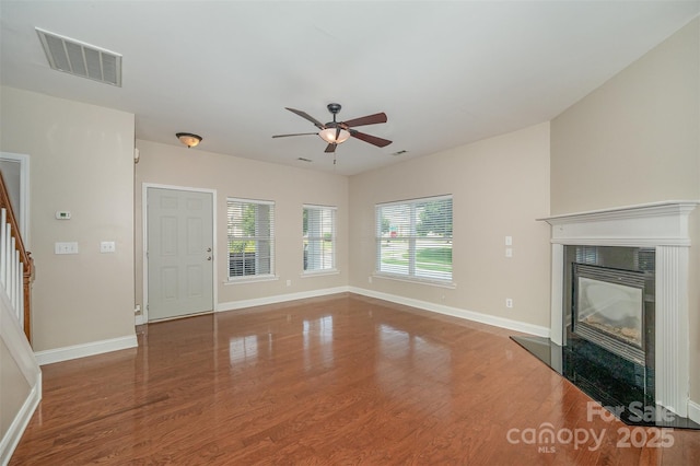 124 Glade Valley Ave, Mooresville, NC 28117 - unfurnished living room with stairway, wood finished floors, a ceiling fan, and a glass covered fireplace