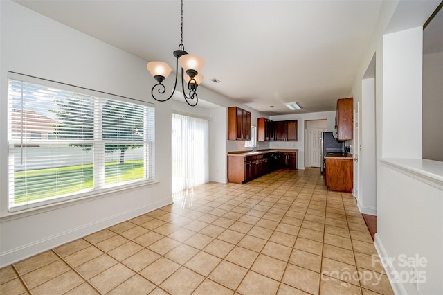 124 Glade Valley Ave, Mooresville, NC 28117 - kitchen featuring a chandelier, light tile patterned floors, light countertops, pendant lighting, and freestanding refrigerator