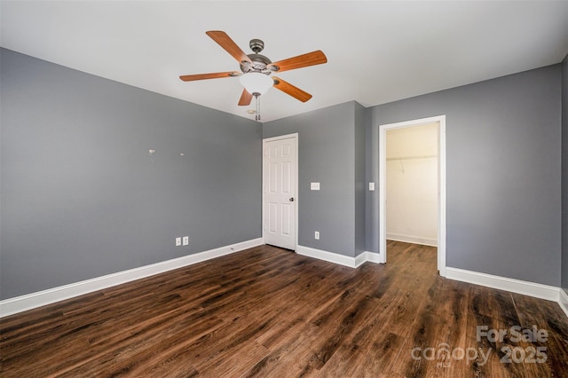124 Glade Valley Ave, Mooresville, NC 28117 - unfurnished bedroom featuring dark wood finished floors, a closet, ceiling fan, and a walk in closet