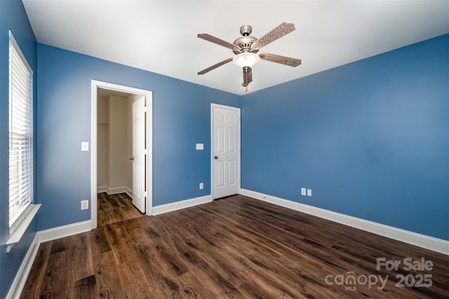 124 Glade Valley Ave, Mooresville, NC 28117 - unfurnished bedroom featuring dark wood-style floors, a closet, a spacious closet, and multiple windows