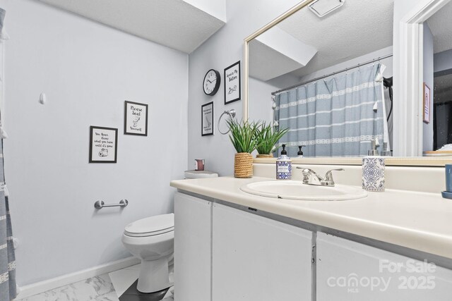 9606 Vinca Cir Unit E, Charlotte, NC 28213 - bathroom with marble finish floors, vanity, and a textured ceiling