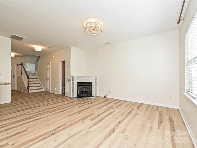 12131 Honor Guard Ave, Charlotte, NC 28277 - unfurnished living room with light wood finished floors, stairs, and a fireplace
