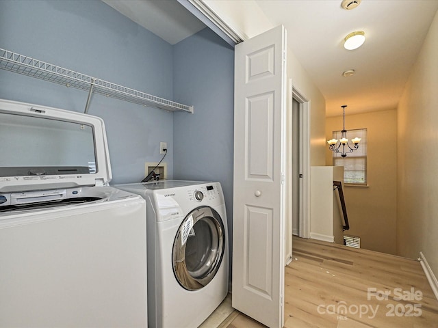 12131 Honor Guard Ave, Charlotte, NC 28277 - laundry room with independent washer and dryer, light wood-type flooring, and a chandelier