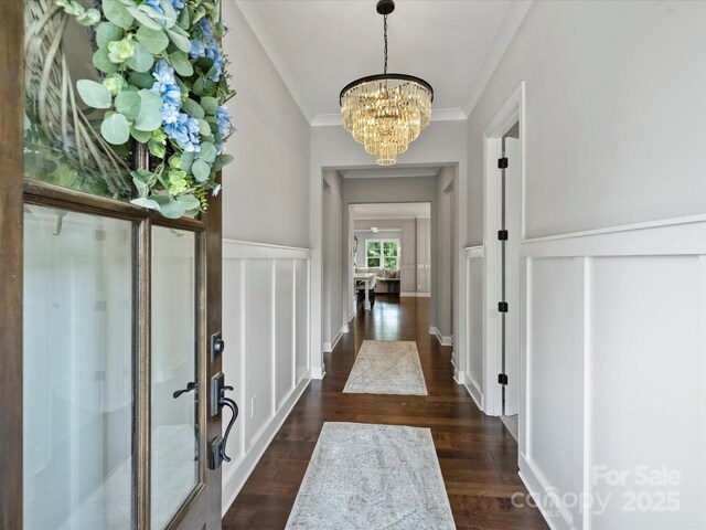 822 River Oaks Ln, Charlotte, NC 28226 - entrance foyer featuring ornamental molding, a chandelier, a decorative wall, wainscoting, and dark wood-style flooring