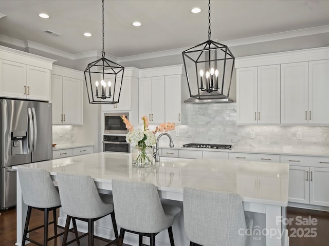 822 River Oaks Ln, Charlotte, NC 28226 - kitchen with appliances with stainless steel finishes, a chandelier, crown molding, decorative backsplash, and a center island with sink