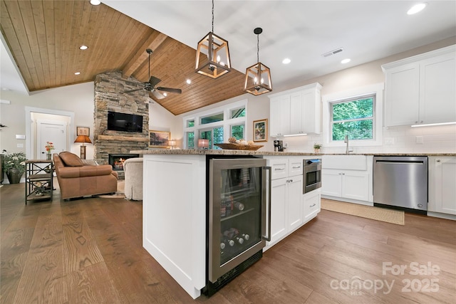 321 Middle Connestee Trl, Brevard, NC 28712 - kitchen featuring dishwasher, wine cooler, a stone fireplace, dark wood-style flooring, and a ceiling fan