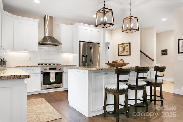 321 Middle Connestee Trl, Brevard, NC 28712 - kitchen with appliances with stainless steel finishes, wall chimney exhaust hood, backsplash, a center island, and a kitchen breakfast bar
