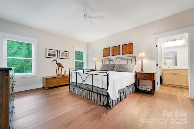 321 Middle Connestee Trl, Brevard, NC 28712 - bedroom with light wood-type flooring, multiple windows, ceiling fan, and ensuite bath