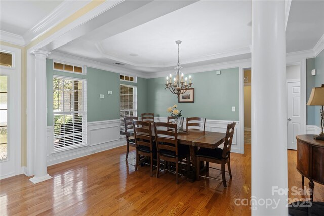 1119 Williamstown Rd, Matthews, NC 28105 - dining room featuring ornate columns, wood finished floors, crown molding, wainscoting, and a chandelier