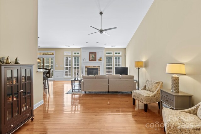 1119 Williamstown Rd, Matthews, NC 28105 - living area featuring ceiling fan, a glass covered fireplace, and light wood-type flooring