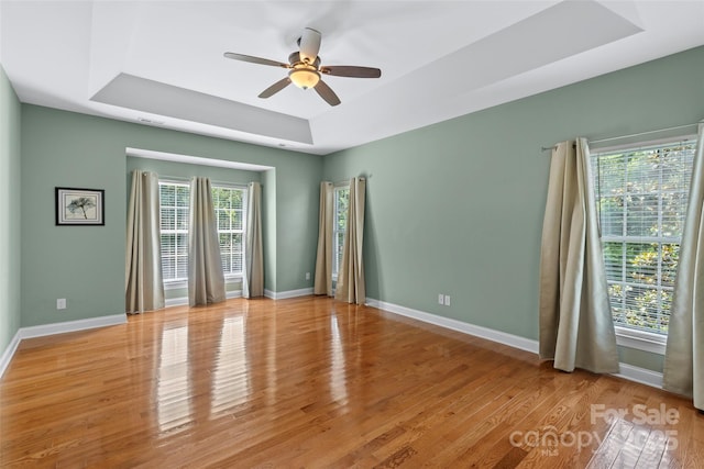 1119 Williamstown Rd, Matthews, NC 28105 - unfurnished room with a tray ceiling, a ceiling fan, and light wood-style flooring