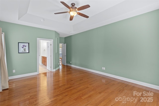 1119 Williamstown Rd, Matthews, NC 28105 - unfurnished bedroom featuring a tray ceiling, light wood-type flooring, a ceiling fan, and ensuite bathroom