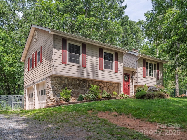 623 Nellie John Dr, Clyde, NC 28721 - view of front facade featuring stone siding, a garage, gravel driveway, a chimney, and view of wooded area
