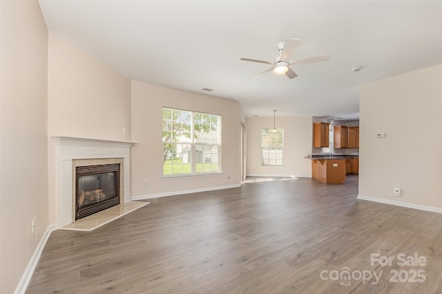 5307 Ayers Orchard Way, Charlotte, NC 28227 - unfurnished living room featuring light wood-type flooring, ceiling fan, and a fireplace