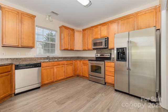 5307 Ayers Orchard Way, Charlotte, NC 28227 - kitchen with appliances with stainless steel finishes, light wood-style flooring, dark stone countertops, and decorative backsplash