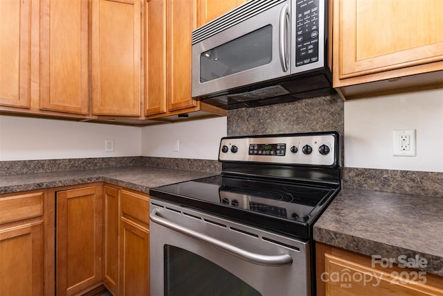 5307 Ayers Orchard Way, Charlotte, NC 28227 - kitchen featuring stainless steel appliances, dark countertops, and brown cabinetry