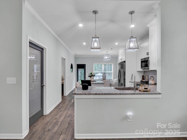 720 4th St, Stanley, NC 28164 - kitchen featuring ornamental molding, stainless steel microwave, white cabinets, dark wood-style flooring, and a peninsula