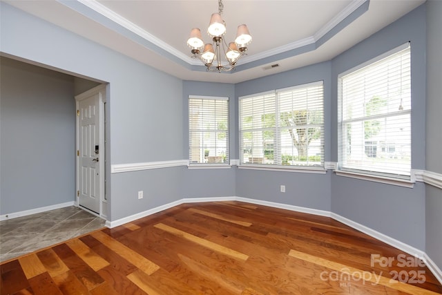 1040 Stonedown Ln, Matthews, NC 28104 - spare room featuring hardwood / wood-style floors, a chandelier, crown molding, and a tray ceiling