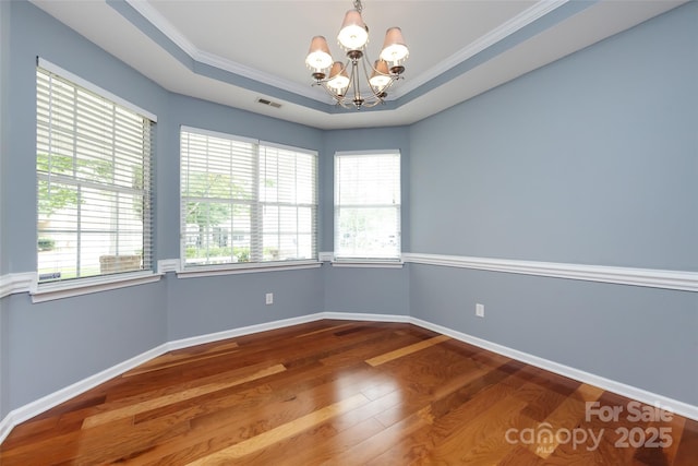 1040 Stonedown Ln, Matthews, NC 28104 - spare room featuring a chandelier, wood finished floors, ornamental molding, and a raised ceiling