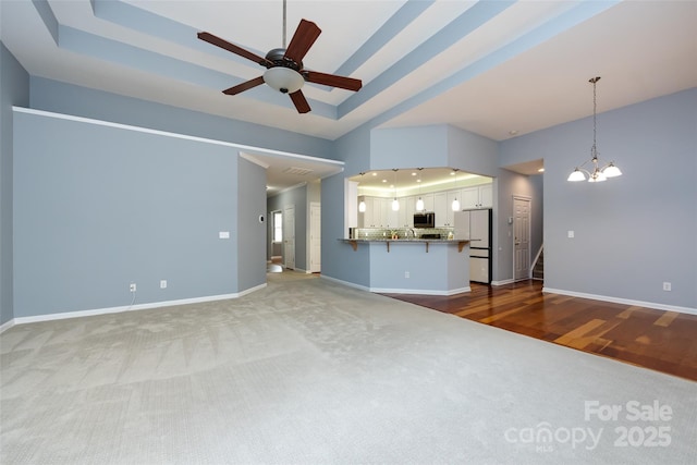 1040 Stonedown Ln, Matthews, NC 28104 - unfurnished living room featuring carpet, a ceiling fan, and a chandelier