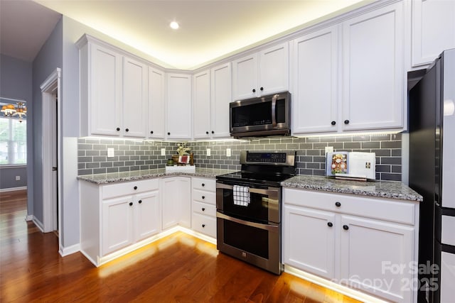 1040 Stonedown Ln, Matthews, NC 28104 - kitchen featuring appliances with stainless steel finishes, dark wood-type flooring, backsplash, light stone counters, and white cabinets