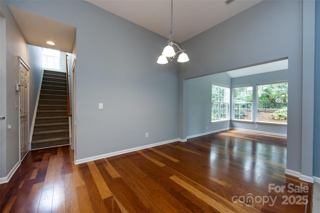 1040 Stonedown Ln, Matthews, NC 28104 - spare room featuring lofted ceiling, a chandelier, hardwood / wood-style flooring, and stairway