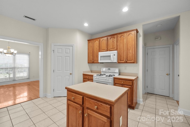 104 Mooreland Dr NE, Conover, NC 28613 - kitchen with white appliances, light tile patterned flooring, a chandelier, light countertops, and brown cabinetry