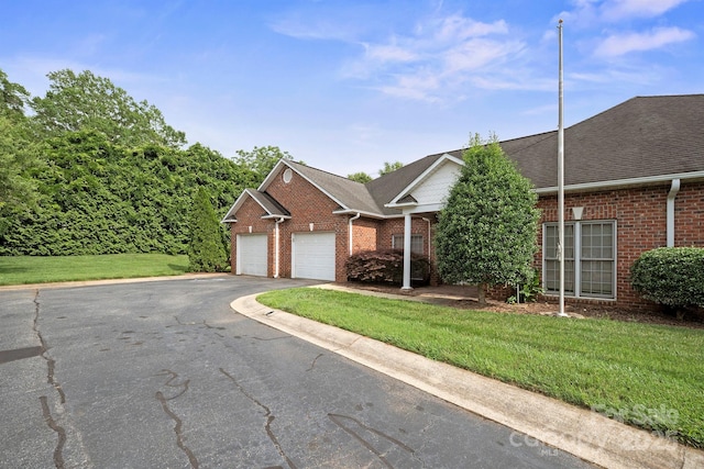 104 Mooreland Dr NE, Conover, NC 28613 - view of front of home featuring brick siding, asphalt driveway, a front yard, a garage, and roof with shingles