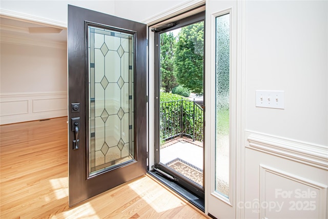 2019 Heirloom Ct, Matthews, NC 28104 - entrance foyer featuring wood finished floors, a decorative wall, crown molding, and wainscoting