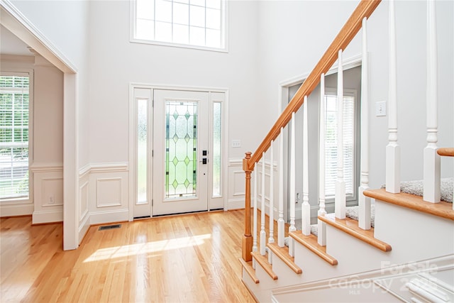 2019 Heirloom Ct, Matthews, NC 28104 - entrance foyer featuring wood finished floors, stairway, a wainscoted wall, a decorative wall, and a towering ceiling
