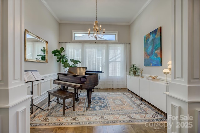 17537 Caddy Ct, Charlotte, NC 28278 - entrance foyer with a chandelier, ornamental molding, light wood-style flooring, and wainscoting