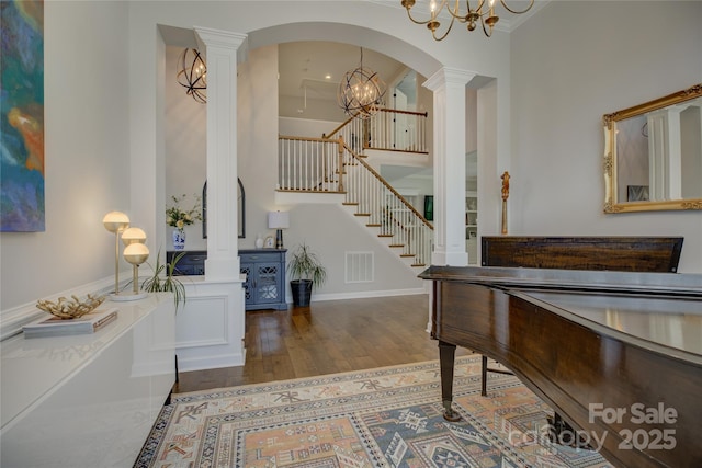 17537 Caddy Ct, Charlotte, NC 28278 - entrance foyer featuring ornate columns, stairs, wood finished floors, a chandelier, and crown molding