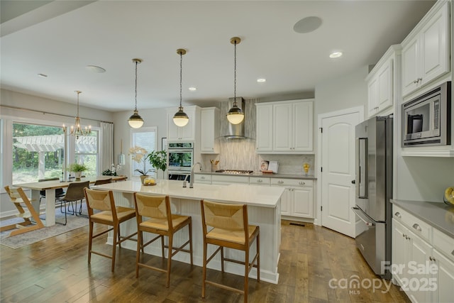 17537 Caddy Ct, Charlotte, NC 28278 - kitchen with stainless steel appliances, wall chimney exhaust hood, backsplash, dark wood-style flooring, and white cabinets