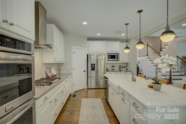 17537 Caddy Ct, Charlotte, NC 28278 - kitchen featuring stainless steel appliances, wall chimney exhaust hood, decorative backsplash, dark wood-type flooring, and white cabinetry