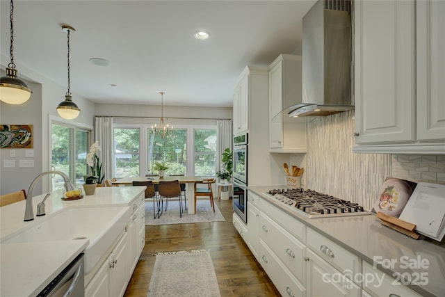 17537 Caddy Ct, Charlotte, NC 28278 - kitchen featuring wall chimney exhaust hood, stainless steel appliances, plenty of natural light, tasteful backsplash, and recessed lighting