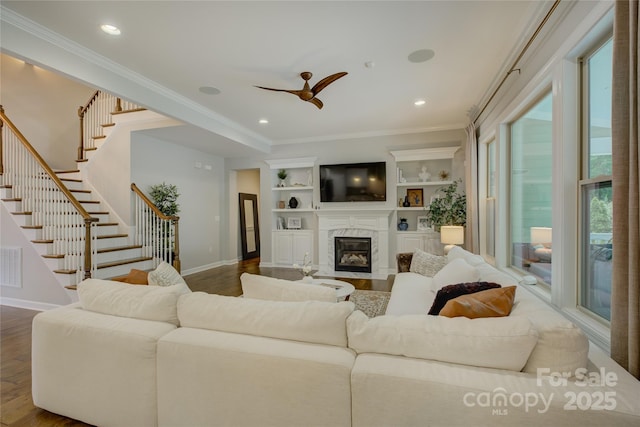 17537 Caddy Ct, Charlotte, NC 28278 - living area with stairs, dark wood-type flooring, crown molding, a fireplace, and ceiling fan