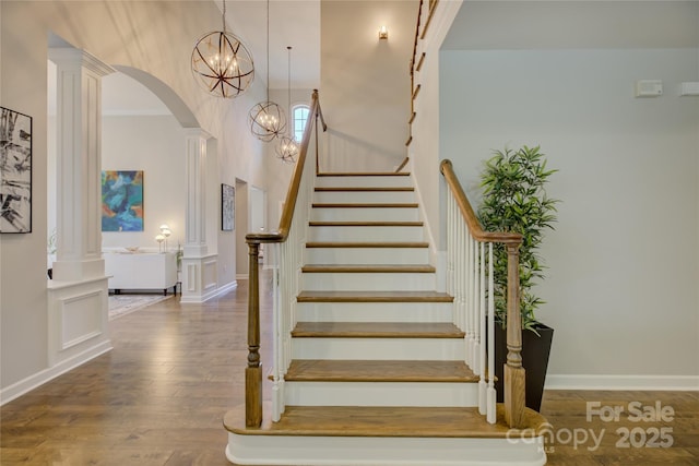 17537 Caddy Ct, Charlotte, NC 28278 - staircase with a chandelier, arched walkways, wood finished floors, and crown molding