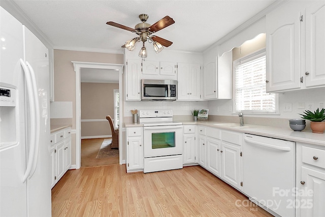 3304 Chilham Pl, Charlotte, NC 28226 - kitchen with white appliances, a ceiling fan, light wood-style flooring, white cabinets, and crown molding