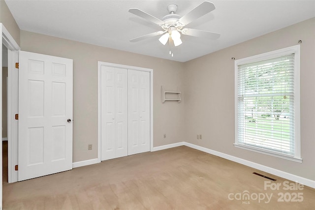 3304 Chilham Pl, Charlotte, NC 28226 - unfurnished bedroom with multiple windows, a closet, a ceiling fan, and light colored carpet