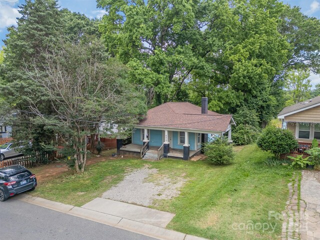 4510 Wildwood Ave, Charlotte, NC 28208 - bungalow-style home featuring a porch, a front yard, a chimney, driveway, and a shingled roof