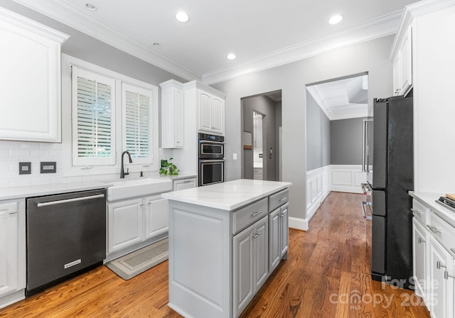 4536 Rustling Woods Dr, Denver, NC 28037 - kitchen featuring stainless steel appliances, white cabinets, a center island, light wood-type flooring, and crown molding